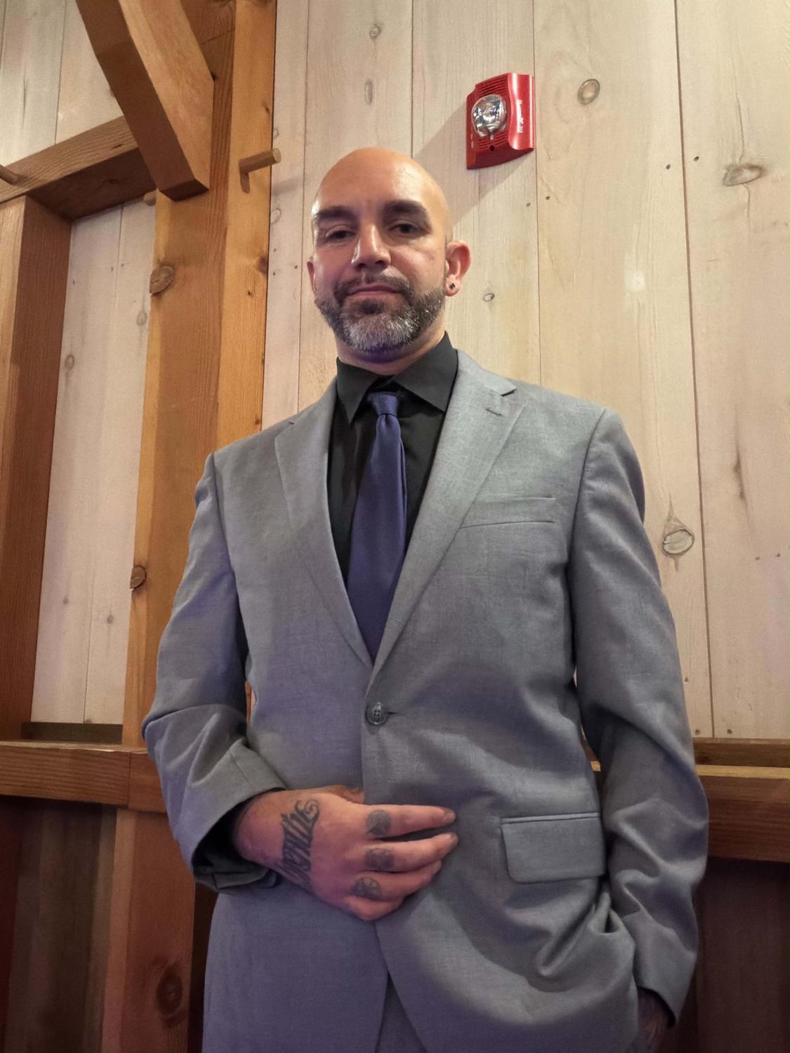 Nick Tenaglia in a gray suit and tie, dressed for a wedding
